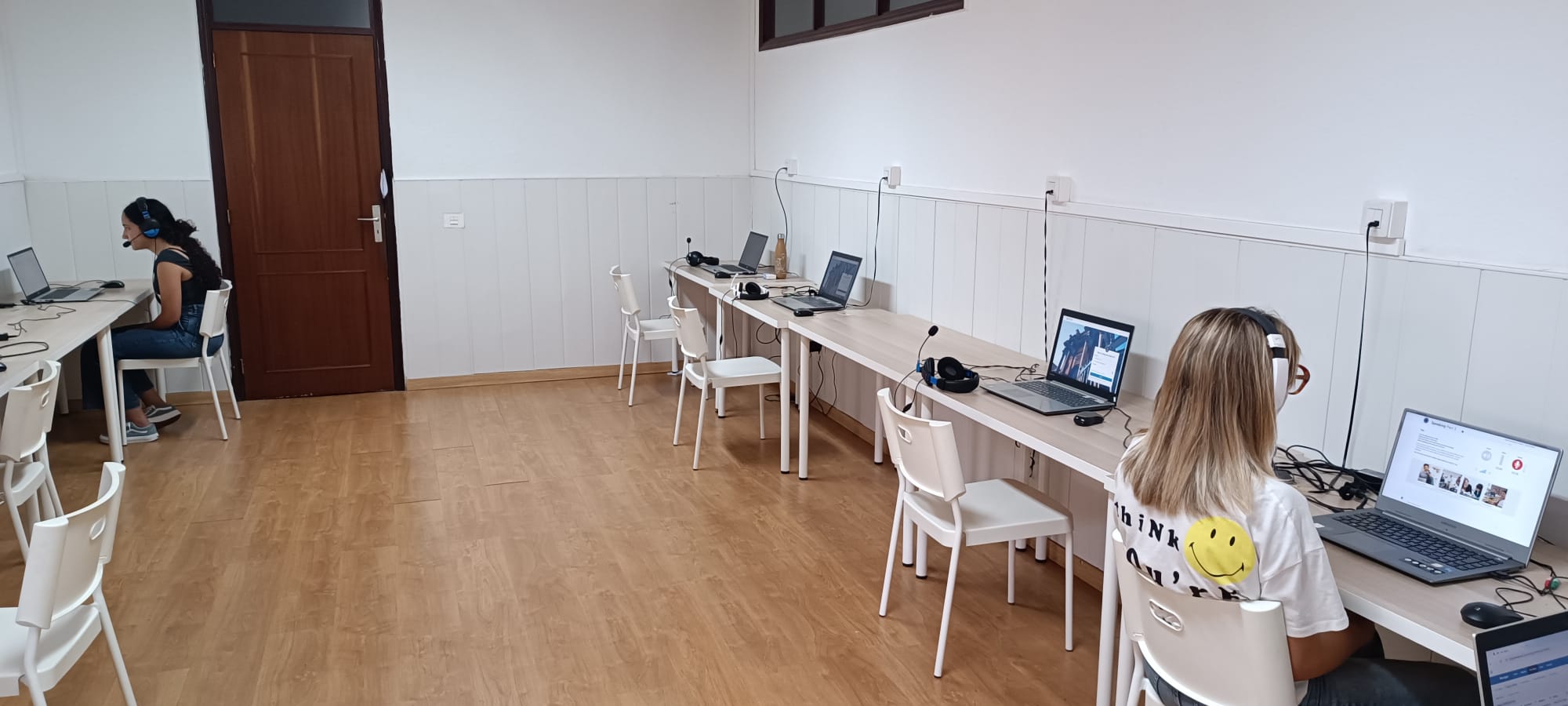 Alumnos sentandos en frente de ordenadores haciendo examen oficial Cambridge, Linguaskill, Oxford Test of English en el Aula de Inglessa específica para los exámenes